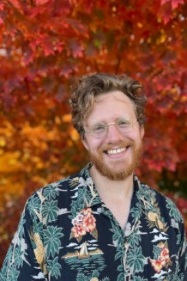Portrait of Renny Hahamovitch in front of red autumn leaves